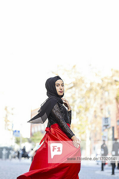 Porträt der jungen schönen Frau trägt Hijab und langen Rock posiert in der Mitte der Stadt Straße