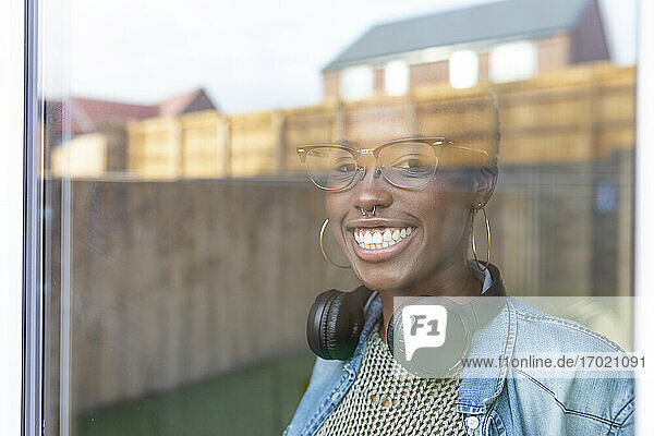 Woman with headphones looking through window