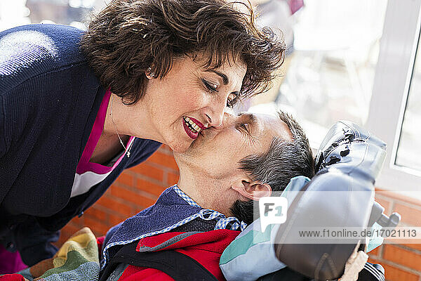 Behinderter Mann küsst Krankenschwester im Pflegeheim