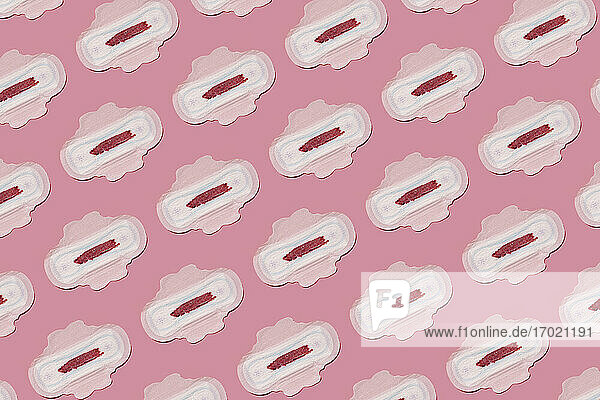 Pattern of bloodstained sanitary pads against pink background