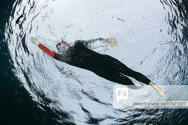 Underwater view of man diving in sea