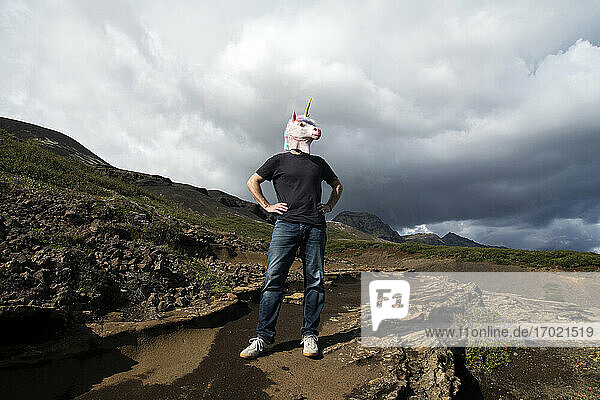 Mann mit Einhornmaske  stehend mit Hand an der Hüfte in Laugarvatnshellir  Reydarbarmur  Island