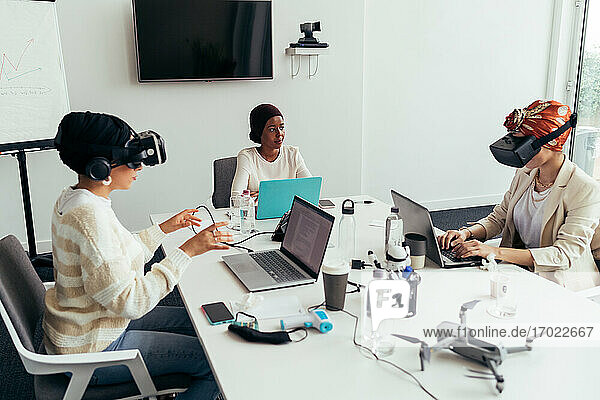 Kollegen benutzen Virtual-Reality-Headsets im Büro