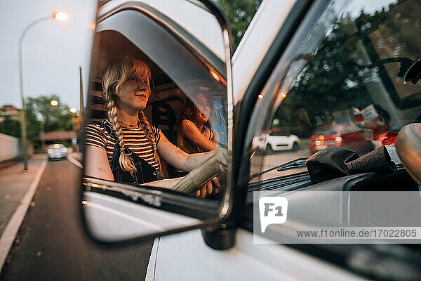 Blick in den Spiegel einer jungen Frau  die einen Lieferwagen fährt
