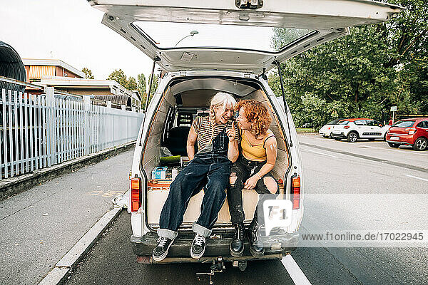 Glückliches lesbisches Paar auf dem Rücksitz eines Vans