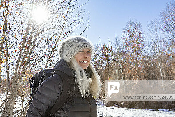 USA  Idaho  Sun Valley  Winterporträt einer lächelnden Frau beim Wandern am Fluss
