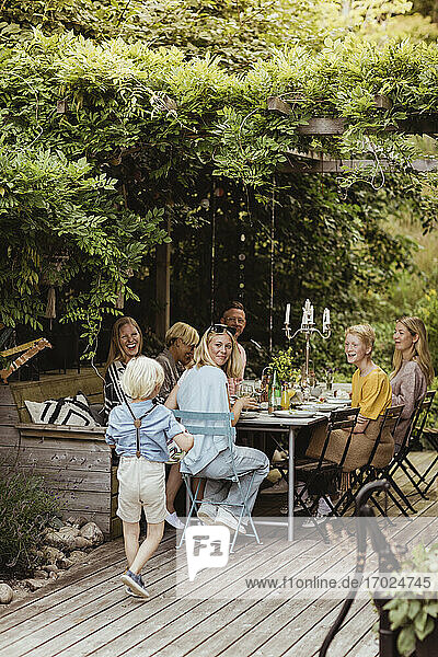 Lächelnde Familie schaut auf Junge zu Fuß während Abendessen Partei im Hinterhof