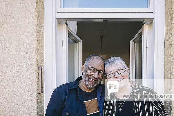 Lächelndes Seniorenpaar auf dem Balkon zu Hause