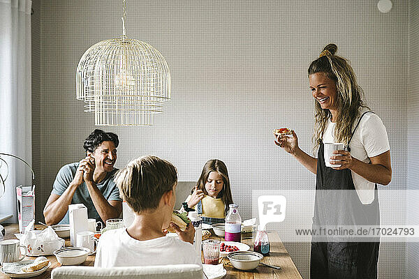 Smiling family having breakfast at dining table