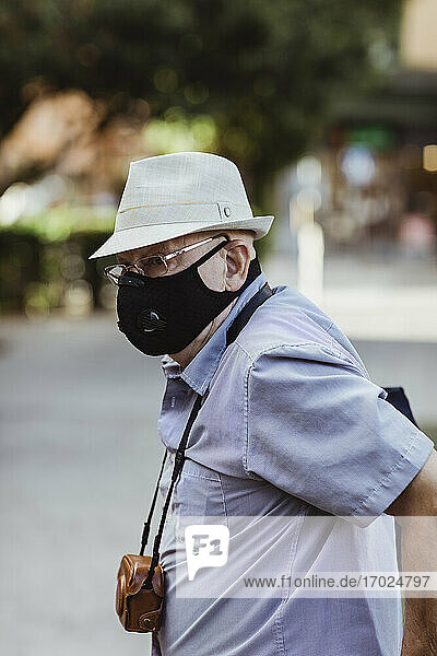 Älterer Mann mit Gesichtsschutzmaske im Park stehend