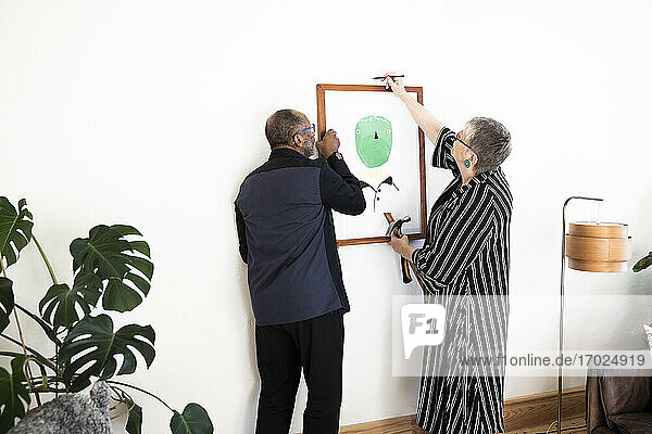 Senior Paar hängen Gemälde an der Wand zu Hause