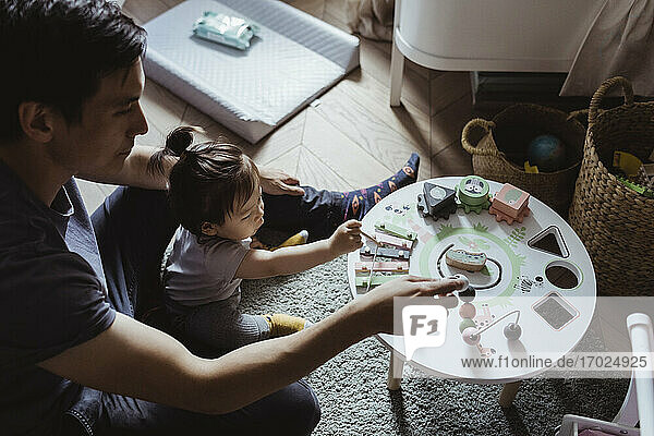 Männliches Kleinkind und Vater spielen mit geometrischem Spielzeug zu Hause