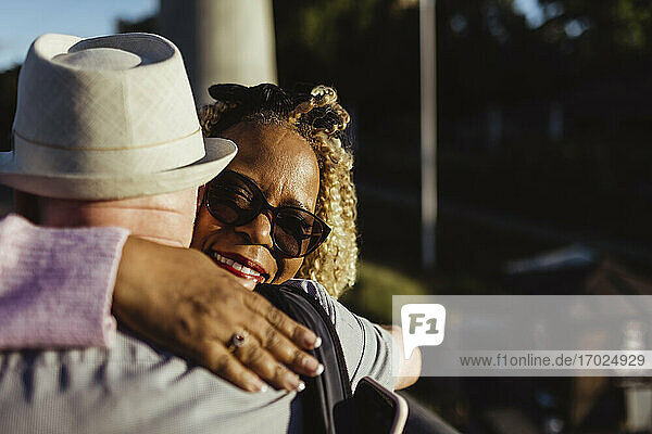 Senior Frau umarmt Mann am sonnigen Tag