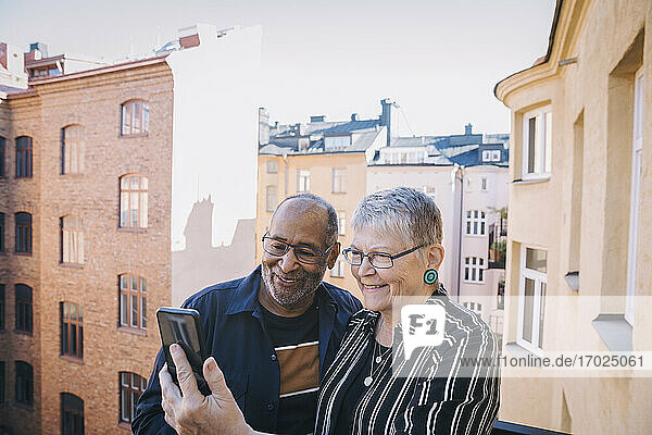 Älteres Paar nimmt Selfie durch Handy in Balkon