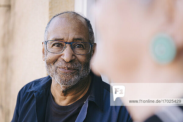 Lächelnder älterer Mann auf dem Balkon