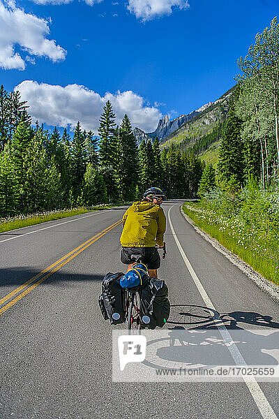 Man cycling on road  Banff National Park  Alberta  Canada