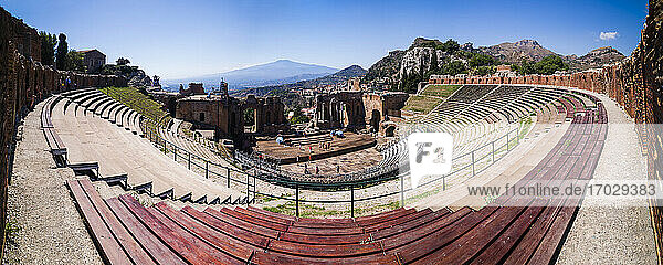 Panorama des Teatro Greco alias Taormina Greek Theatre  Blick auf das Amphitheater und den Vulkan Ätna  Sizilien  Italien  Europa. Dies ist ein Panorama von Teatro Greco alias Taormina Griechisches Theater zeigt den Panoramablick auf das Amphitheater mit dem Vulkan Ätna im Hintergrund  Sizilien  Italien  Europa.