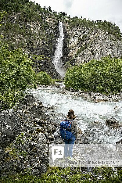 Hiker standing on the bank  Driva river  Svøufallet waterfall  Åmotan gorge  Gjøra  Norway  Europe