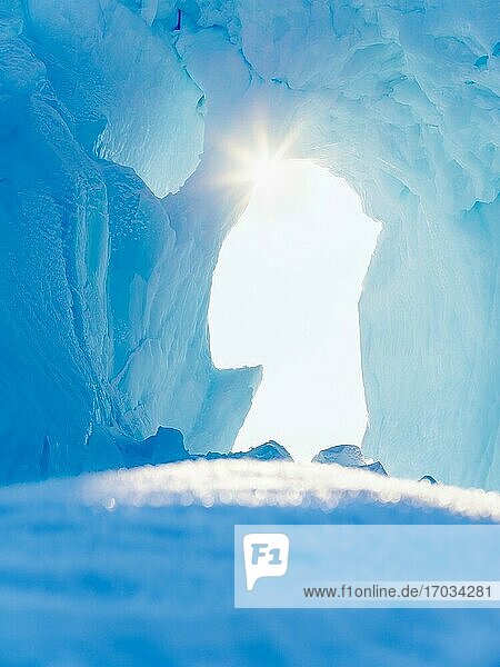 Iceberg frozen into the sea ice of the Uummannaq fjord system during winter in the the north west of Greenland  far beyond the polar circle. North America  Greenland  danish territory.