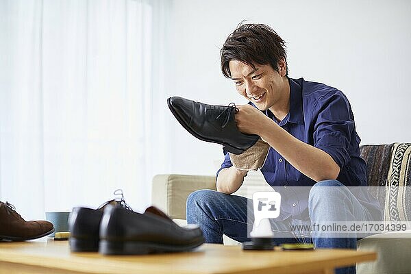 Japanese man cleaning shoes at home