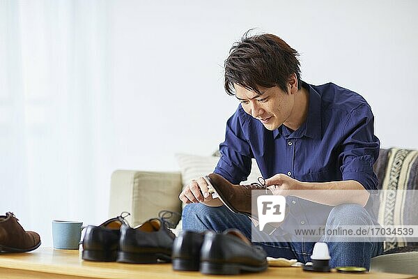 Japanischer Mann putzt Schuhe zu Hause