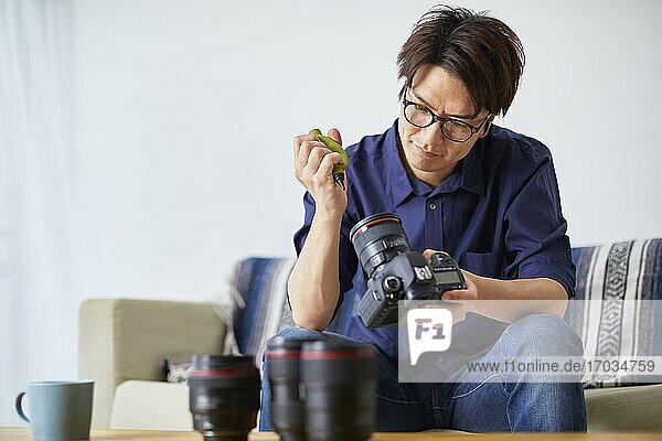Japanischer Mann reinigt Kamera zu Hause