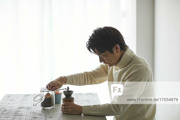 Japanischer Mann kocht zu Hause Kaffee