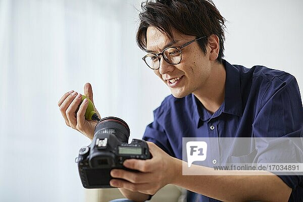 Japanese man cleaning camera at home