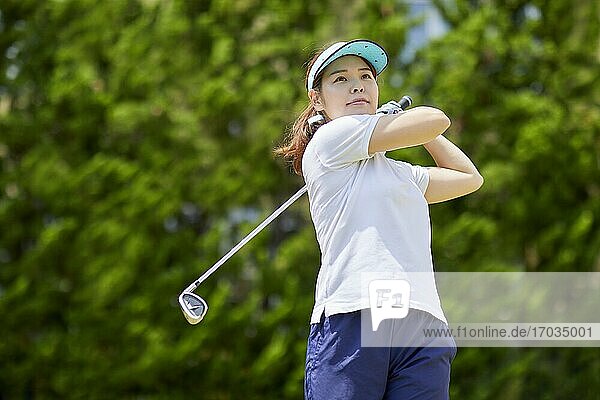 Japanese woman practicing golf in the garden
