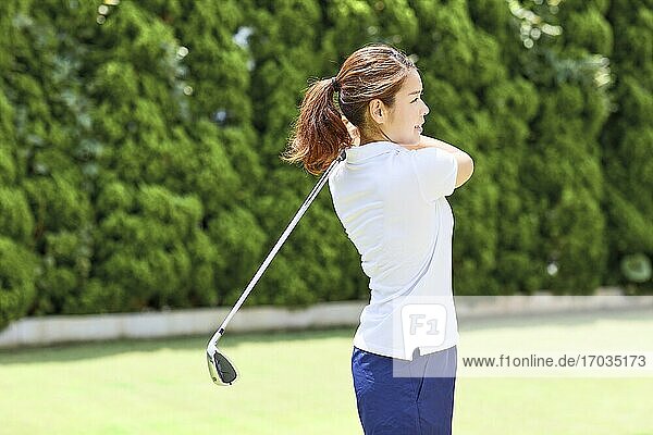 Japanese woman practicing golf in the garden