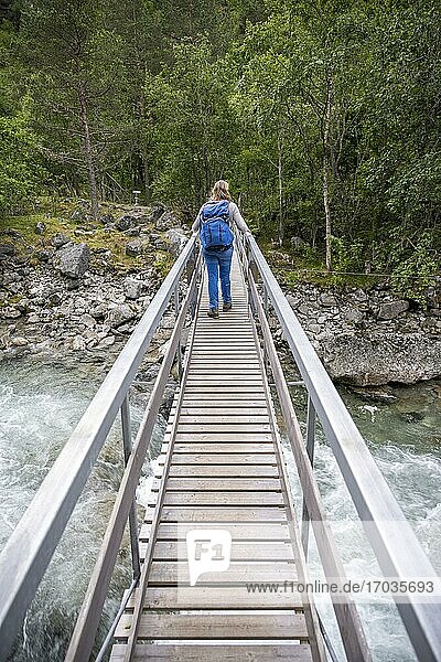 Wanderin auf Holzbrücke über den Fluss Driva  Åmotan Schlucht  Gjøra  Norwegen  Europa