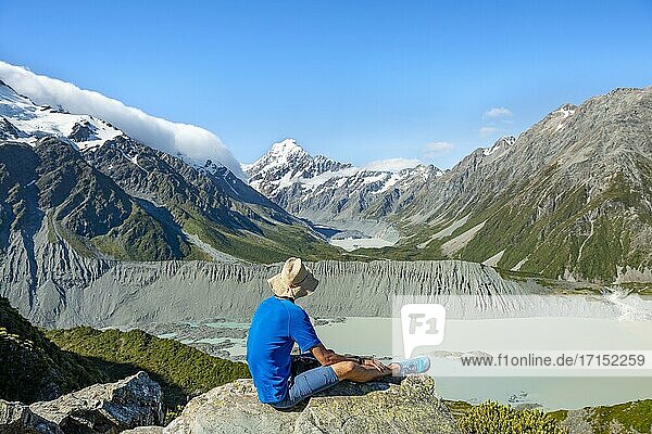 Hiker sitting on a rock  view of Hooker Valley with Mueller Lake  Hooker Lake and Mount Cook  Sealy Tarns Track  Hooker Valley  Mount Cook National Park  Southern Alps  Canterbury  South Island  New Zealand  Oceania