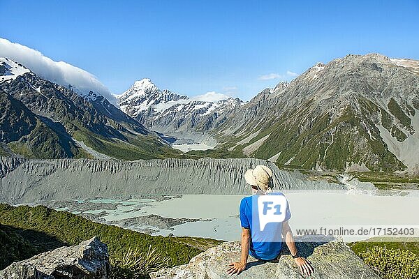 Hiker sitting on a rock  view of Hooker Valley with Mueller Lake  Hooker Lake and Mount Cook  Sealy Tarns Track  Hooker Valley  Mount Cook National Park  Southern Alps  Canterbury  South Island  New Zealand  Oceania