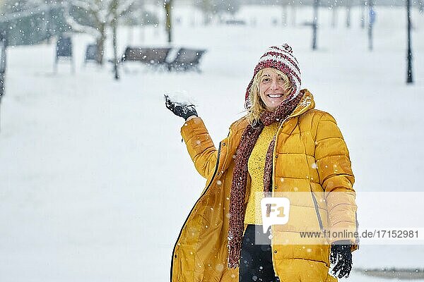 Kaukasische junge Frau wirft einen Schneeball im Freien im Winter. Navarra  Spanien  Europa.