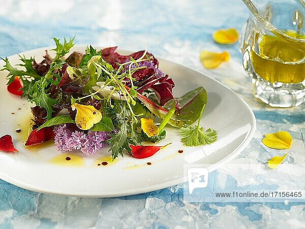 Salat mit essbaren Blüten und Weißwein.