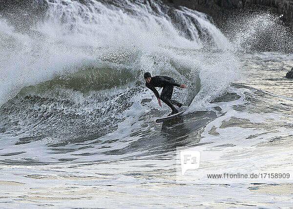 Männlicher Surfer beim Surfen auf dem Meer am Broad Haven South Beach  Wales  UK