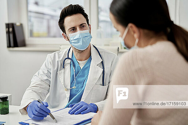 Male doctor talking with patient in clinic