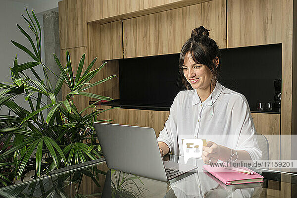 Portrait of young woman shopping online at home