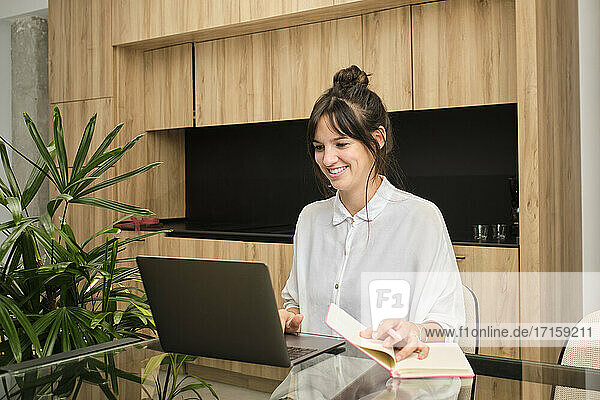 Porträt einer jungen Frau  die zu Hause am Laptop arbeitet