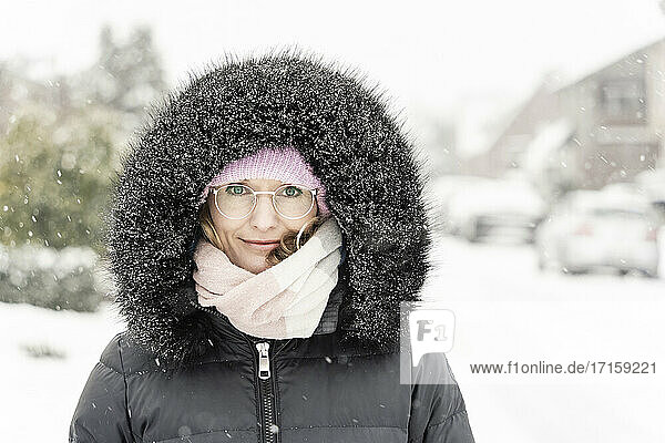 Woman in hooded anorak during snowfall