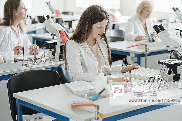 Young female researcher working in science class