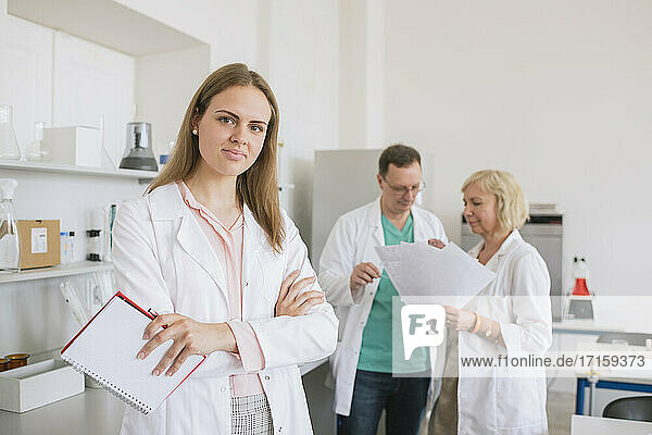 Portrait of young researcher in white coat in a lab