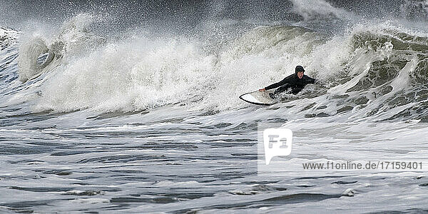 Junger Mann beim Surfen auf dem Meer am Broad Haven South Beach  Wales  UK