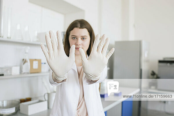 Blick auf eine Wissenschaftlerin mit Handschuhen im Labor