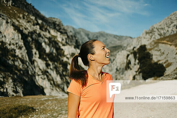 Smiling woman looking at mountain view while standing at Cares Trail in Picos De Europe National Park  Asturias  Spain