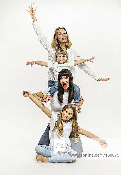 Smiling women with daughters gesturing in studio