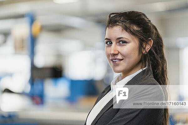 Businesswoman smiling while standing at industry