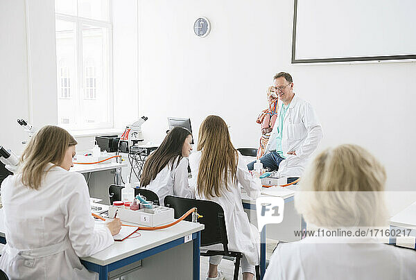 Studenten halten eine Vorlesung mit einem Professor in einem wissenschaftlichen Labor
