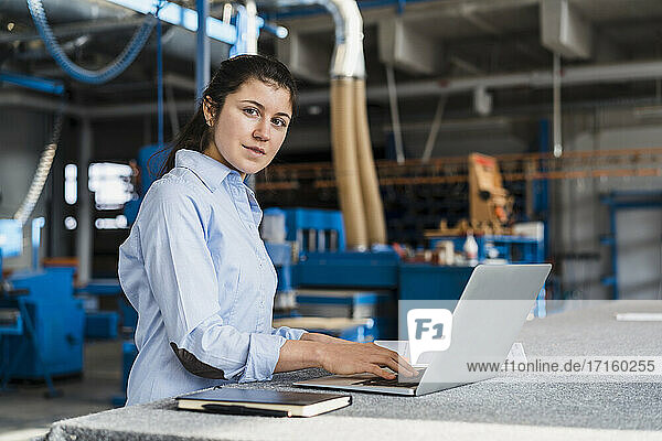 Businesswoman using laptop while working at industry