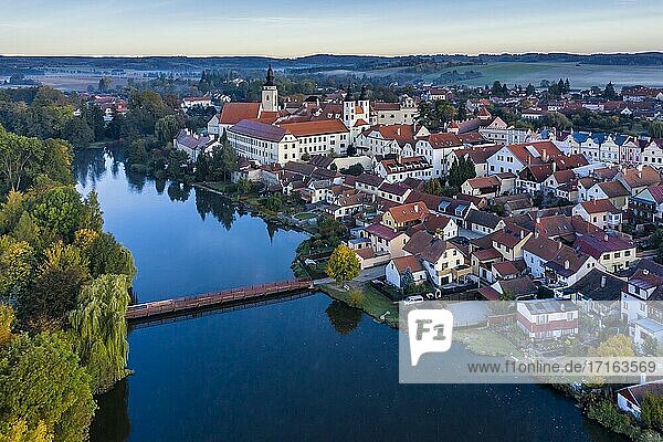 Aerial view before sunrise of the Telc Castle with foreground bridge and pond in the Czech Republic.